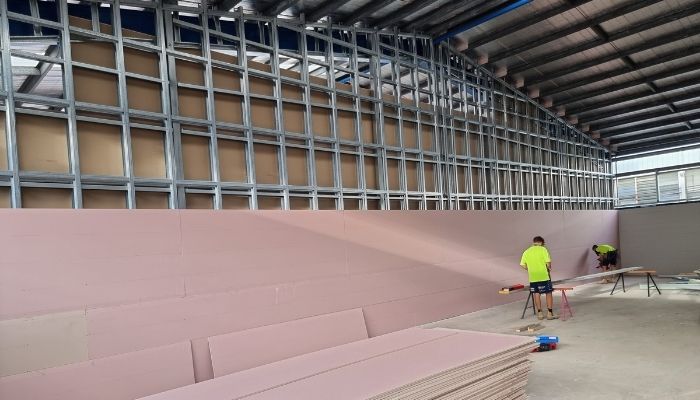 Installation of fyrcheck paneling on firewall in commercial warehouse project in Townsville by IK Building and Construction
